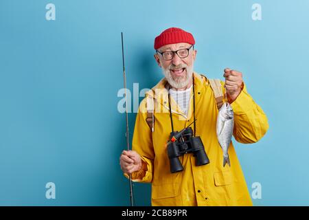 Unrasiert glücklich überglücklich alten Mann mit weit offenen Mund jubelte über seine erfolgreiche Kath. Nahaufnahme Foto. Isoliert blauen Hintergrund, Hobby, Interets, Kopie Stockfoto