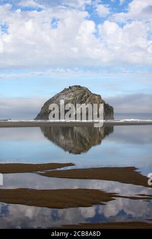 Der berühmte Cannon Rock an der Küste von Oregon spiegelt sich in Low wider Gezeiten an einem schönen wolkigen Tag Stockfoto