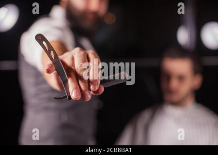 Male Barber zeigt einen Barbier s Rasierer, zum Rasieren von Bart oder Schneiden Haare, Nahaufnahme verwendet. Werkzeuge Zubehör Von Friseur. Barbershop-Konzept Stockfoto