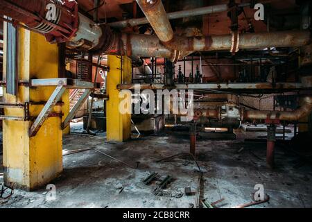 Alte rostige Industrietanks, die durch Rohre verbunden sind, die mit Ventilen in einer verlassenen Chemiefabrik verbunden sind Stockfoto