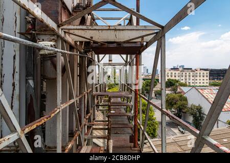 Fußgängerüberführung in der alten Fabrik. Rostiger Metall, gefährlicher Ort. Metallstruktur Stockfoto