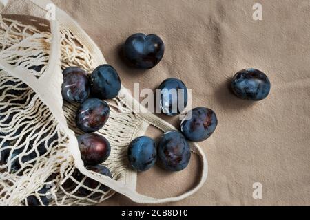 Bio Pflaumen in den wiederverwendbaren Öko-Saiten Lebensmittelbeutel. Einkaufstasche mit Früchten. Gemüse auf dem lokalen Markt. Produkte für Landwirte. Ökologisches Lifestyle-Konzept. Stockfoto