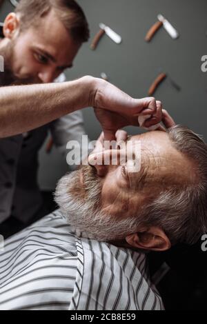 Caucasin alter Mann seinen Bart abrasiert bekommen von Friseur Besuch hairtician bei der Rasur Limousine, in der Nähe Stockfoto