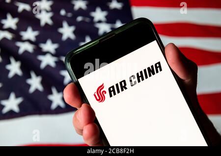In dieser Abbildung ist die chinesische Flagge Träger, Air China Logo auf einem Android-Handy mit Flagge der Vereinigten Staaten von Amerika im Hintergrund zu sehen. Stockfoto