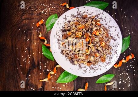 Müsli mit getrockneten Früchten, Mohn, Grapefruit auf Holzgrund Stockfoto