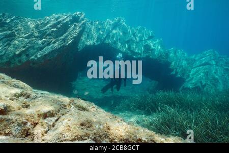 Felsformation, natürlicher Bogen unter Wasser mit einem Mann freitauchend im Mittelmeer, Katalonien, Cap de Creus, Costa Brava, Spanien Stockfoto