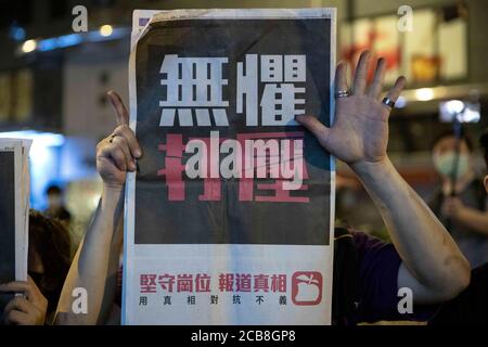 Hongkong, China. August 2020. Anhänger der Demokratie halten Apple Daily Zeitungen mit "fünf Forderungen, nicht einer weniger" Handbewegung vor der Mongkok Polizeistation am späten Montag. Der pro-demokratische Medien-Tycoon in Hongkong und der Gründer von Apple Daily, Jimmy Lai, der am Montag nach dem neuen nationalen Sicherheitsgesetz verhaftet wurde, verlassen die Polizeistation Mong Kok, nachdem er am frühen Dienstag, dem 12. August 2020, gegen Kaution in Hongkong, China, freigelassen wurde. Nach Angaben der örtlichen Polizei wurde Lai wegen des Verdachts der "Kolludierung mit ausländischen Mächten verhaftet. Quelle: May James/ZUMA Wire/Alamy Live News Stockfoto