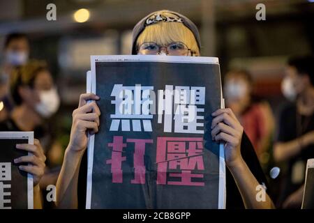 Hongkong, China. August 2020. Anhänger der Demokratie halten am späten Montag vor der Polizeistation Mongkok die Apple Daily-Zeitungen. Der pro-demokratische Medien-Tycoon in Hongkong und der Gründer von Apple Daily, Jimmy Lai, der am Montag nach dem neuen nationalen Sicherheitsgesetz verhaftet wurde, verlassen die Polizeistation Mong Kok, nachdem er am frühen Dienstag, dem 12. August 2020, gegen Kaution in Hongkong, China, freigelassen wurde. Nach Angaben der örtlichen Polizei wurde Lai wegen des Verdachts der "Kolludierung mit ausländischen Mächten verhaftet. Quelle: May James/ZUMA Wire/Alamy Live News Stockfoto