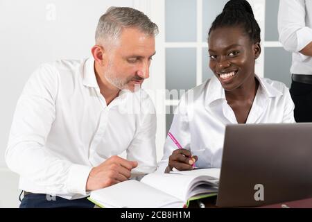 African American businesswoman Consulting Client über Kredit oder Versicherung in der Vorstandsetage, verschiedene Kollegen arbeiten an Online-Projekt zusammen Stockfoto