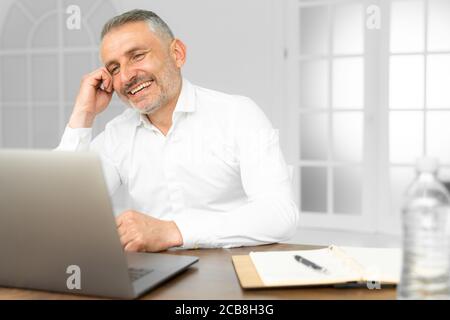 Erfolgreiche Unternehmer Arbeiten am Laptop in der modernen Luxus Büro Schreibtisch. Junge Unternehmer mit Arbeit Ergebnis der Analyse finanzieller Indikatoren zufrieden auf Stockfoto