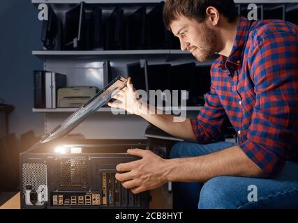 Guy arbeitet an einem kleinen Computer-Reparatur-Unternehmen, Mann Diagnose Computer-Probleme Stockfoto