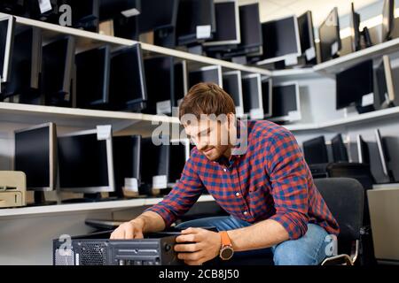 Gut aussehende Mann genießen die Arbeit mit System-Einheit, Nahaufnahme Foto. Copy Space, Mann, der für Kunden Stockfoto