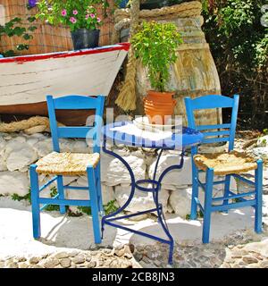 Charmante traditionelle Straßenbars und Tavernen von Griechenland mit typischen bunten Holzstühlen. Kos-Insel Stockfoto