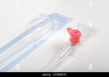 Medizinisches Venflon zur Verabreichung von intravenösen Flüssigkeiten. Medizinisches Zubehör, das in der Intensivpflege benötigt wird. Heller Hintergrund. Stockfoto
