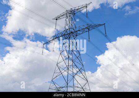 Ein großer Metall-Strompylon oder Übertragungsturm gegen ein Blauer Himmel mit Wolken Stockfoto