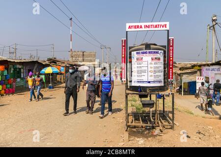 Ein großer Plastikwassertank mit Freihandwaschschild darauf, um Coronavirus an der Seite einer Feldstraße zu bekämpfen, Nairobi, Kenia Stockfoto