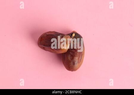 High-Angle-Aufnahme von zwei trockenen Daten isoliert auf einem Rosa Oberfläche Stockfoto