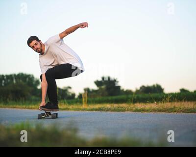 Shallow Focus Aufnahme eines jungen hübschen Mannes, der eine reitet Skateboard Stockfoto