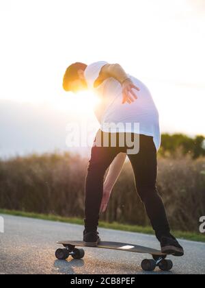 Shallow Focus Aufnahme eines jungen hübschen Mannes, der eine reitet Skateboard Stockfoto