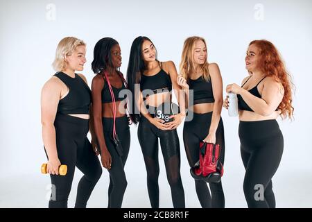 Junge attraktive Mädchen in schwarzer Sportbekleidung stehen zusammen, fördern das Sportleben, gesundes Lifestyle-Konzept, Sport Stockfoto