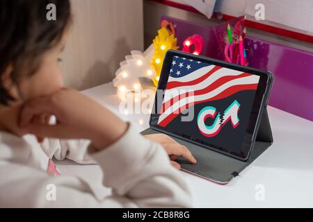 Antalya, TÜRKEI - 07. August 2020. Tablet mit amerikanischer Flagge und gebrochenem tiktok-Logo auf dunklem Hintergrund Stockfoto