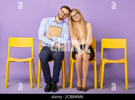 Lächelnd freundliche weibliche und männliche Mitarbeiter tragen Brille und halten Papiere in den Händen in der Kamera und warten auf Job Interview Stockfoto