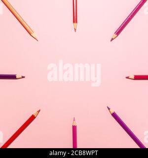 Rot, rosa, lila und orange Bleistifte in einem Kreis ändern Orte flach Lay Top-Ansicht auf Buntstifte Hintergrund mit Kopierraum. Bildungskonzept Stockfoto