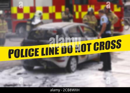 Polizeibeamter und Feuerwehrleute stehen bei ausgebranntem Autowrack mit gelbem Polizeiband mit Text Polizeilinie kreuzen nicht. Selektiver Fokus auf gelbem t Stockfoto