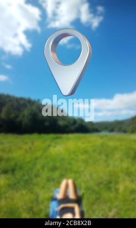 Eine Person liegt auf einer grünen Wiese unter einem großen Wegpunkt-Symbol - 3d-Abbildung Stockfoto