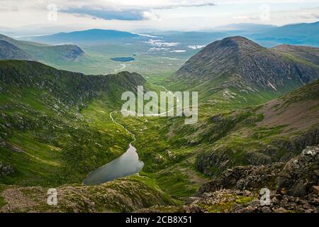 Wunderschöne schottische Berglandschaft. Blick vom Gipfel des Stob Ghabhar hinunter in Richtung Coirein Lochain und Rannoch Moor am Horizont. Stockfoto