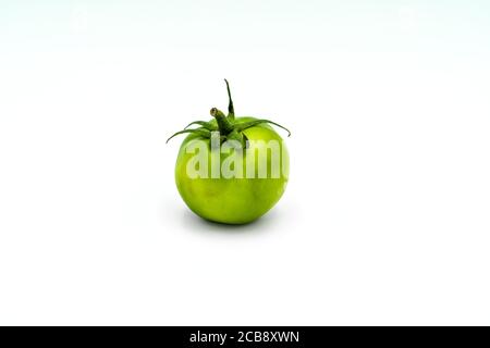 Eine grüne Zebratomate auf weißem Hintergrund. Perfekte Aufnahme für Veganismus und mediterrane Ernährung. Stockfoto