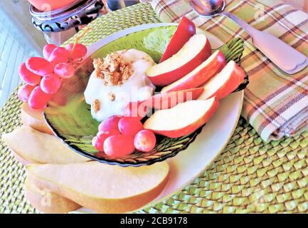 Frische Obstscheiben auf einem Teller mit Joghurt und Müsli Stockfoto