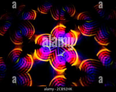 3D-Rendering oder 3D-Rendering. Kaleidoskopisches dreidimensionales Bild. Symmetrie mit farbigen Lichtern auf schwarzem Hintergrund. Stockfoto