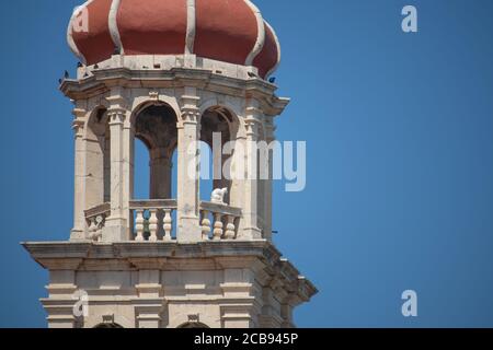 Vergrößert im Blick auf den glockenturm der christlichen Kirche in der kleinen Stadt Sutivan auf der Insel brac. Statue einer kleinen weißen Katze im Glockenturm Stockfoto