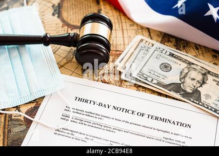 Dreißig Tage Kündigungsmitteilung Dokument, auf dem Hintergrund der amerikanischen Flagge mit Dollar und hygienischen Masken. Stockfoto