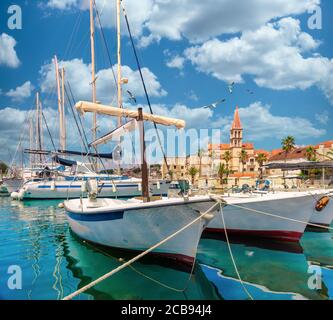 Schöne Panorama malerische Aussicht auf eine kleine Stadt Milna auf der Insel Brac. Alte Boote dockten im kristallklaren Meer an, warmer Sommertag. Stockfoto