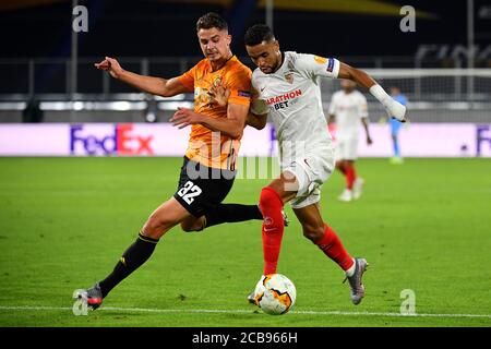 (200812) -- DUISBURG, 12. August 2020 (Xinhua) -- Youssef en-Nesyri (R) aus Sevilla steht mit Leander Dendoncker aus Wolverhampton Wanderers während des UEFA Europa League Viertelfinales zwischen Wolverhampton Wanderers und dem FC Sevilla in Duisburg, Deutschland, 11. August 2020. NUR FÜR REDAKTIONELLE ZWECKE. NICHT ZUM VERKAUF FÜR MARKETING- ODER WERBEKAMPAGNEN. (Stuart Franklin/UEFA/Getty/Handout über Xinhua) Stockfoto