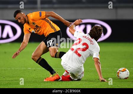 (200812) -- DUISBURG, 12. August 2020 (Xinhua) -- Romain Saiss (L) von Wolverhampton Wanderers steht mit Franco Vazquez aus Sevilla während des UEFA Europa League Viertelfinales zwischen Wolverhampton Wanderers und dem Sevilla FC in Duisburg, Deutschland, 11. August 2020. NUR FÜR REDAKTIONELLE ZWECKE. NICHT ZUM VERKAUF FÜR MARKETING- ODER WERBEKAMPAGNEN. (Stuart Franklin/UEFA/Getty/Handout über Xinhua) Stockfoto