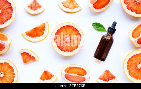 Flasche ätherisches Öl mit Grapefruitscheiben auf weißem Hintergrund. Hoher Vitamin C. Stockfoto