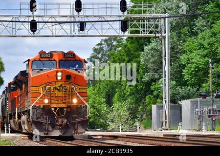 Hinsdale, Illinois, USA. Ein Paar Lokomotiven führen einen Burlington Northern Santa Fe Manifest Güterzug unter einer Signalbrücke. Stockfoto