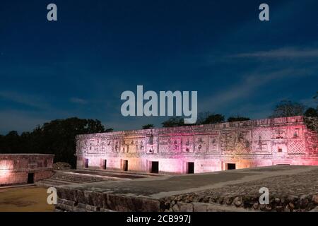 Das westliche Gebäude des Nunnery Quadrangle wird von farbigen Lichtern in den prähispanischen Maya-Ruinen von Uxmal, Mexiko, beleuchtet. Stockfoto