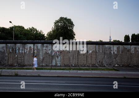 Berlin, Deutschland. August 2020. Eine Frau geht am frühen Morgen entlang der Bernauer Straße entlang der Berliner Mauer. Vor 59 Jahren, am 13. August 1961, begann der Bau der Mauer, die Berlin für mehr als 28 Jahre teilte. Quelle: Christoph Soeder/dpa/Alamy Live News Stockfoto