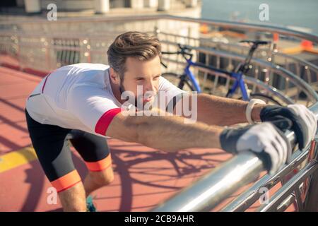 Mann in Sportbekleidung und Handschuhe beim Stretching Stockfoto