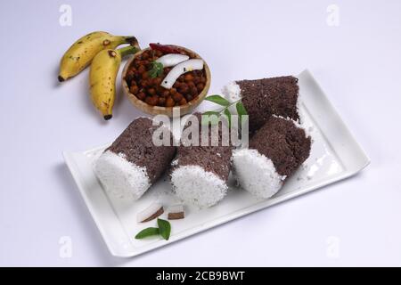 Ragi Puttu oder Millet Puttu, hausgemachtes kerala Frühstück gemacht Mit Fingerhirse und Kokosnüsse, indische Lebensmittel auf einem gelegt Weißes Geschirr mit Ka Stockfoto