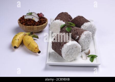 Ragi Puttu oder Millet Puttu, hausgemachtes kerala Frühstück gemacht Mit Fingerhirse und Kokosnüsse, indische Lebensmittel auf einem gelegt Weißes Geschirr mit Ka Stockfoto