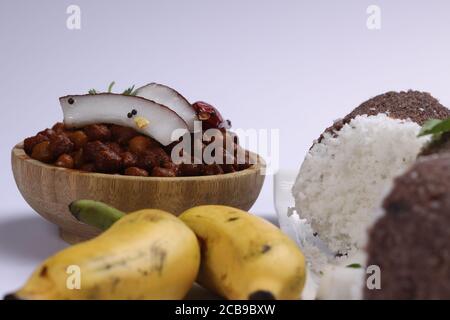 Ragi Puttu oder Millet Puttu, hausgemachtes kerala Frühstück gemacht Mit Fingerhirse und Kokosnüsse, indische Lebensmittel auf einem gelegt Weißes Geschirr mit Ka Stockfoto