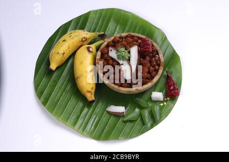 Kadala Curry oder Bengalen Gram Curry, hausgemachtes Chana Curry in einer Holzschüssel angeordnet und garniert mit Kokosnussscheiben, trockenem Chili und Curryblättern auf BA Stockfoto