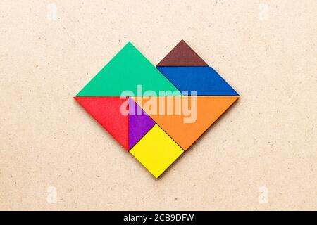 Farbe Tangram Puzzle in Herzform auf Holz Hintergrund Stockfoto