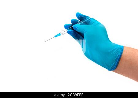 Hand des Mannes in blauem Latexhandschuh hält Plastikspritze isoliert auf weißem Hintergrund. Medizinisches Konzept Stockfoto