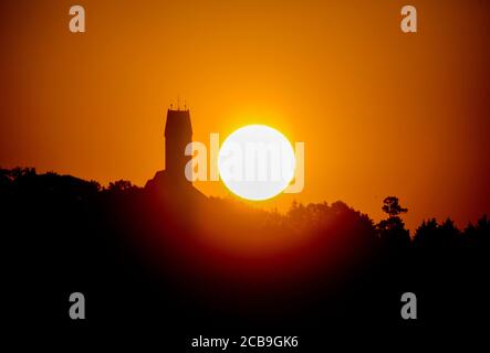 Unlingen, Deutschland. August 2020. Neben der Wallfahrtskirche St. Johannes Baptist auf dem Bussen-Berg geht morgens die Sonne auf. Der Bussen ist einer der meistbesuchten Wallfahrtsorte in Oberschwaben. Kredit: Thomas Warnack/dpa/Alamy Live Nachrichten Stockfoto